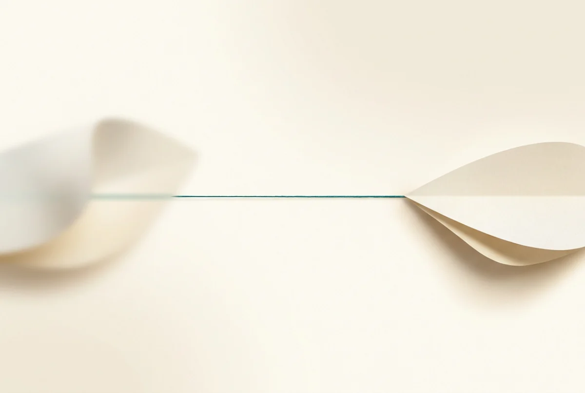 Warm illustration of a soft blurred shape becoming a crisply defined one as it travels along a single teal thread